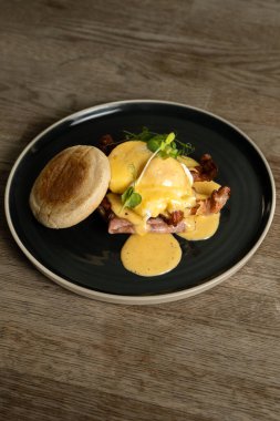 Benedict usulü yumurta, domuz pastırması ve jambon.