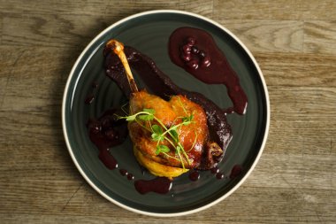 Patates püresi üzerine kızarmış ördek bacağı soğan, mor lahana kreması ve yabanmersini suyu.