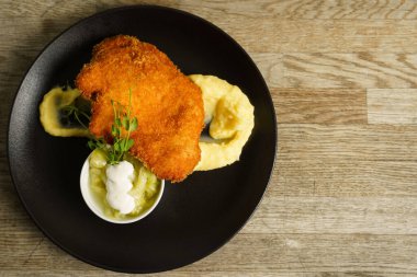 Şnitzel, kızarmış tavuk, salatalık salatası ve patates püresi.