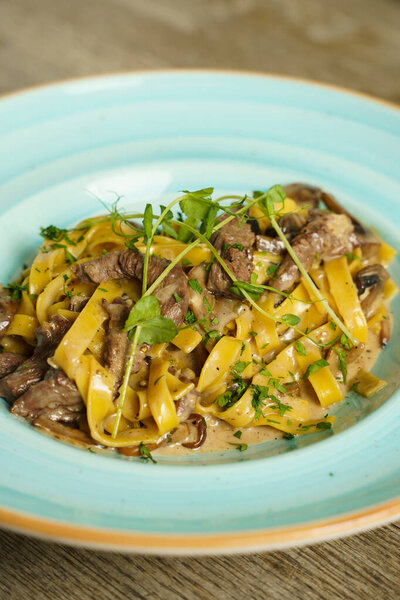 Pork with pasta and mushroom sauce