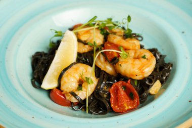 Karides, acı biber ve sarımsaklı siyah tagliatelle makarna.