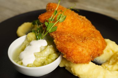 Şnitzel, kızarmış tavuk, salatalık salatası ve patates püresi.