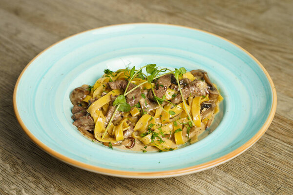 Pork with pasta and mushroom sauce