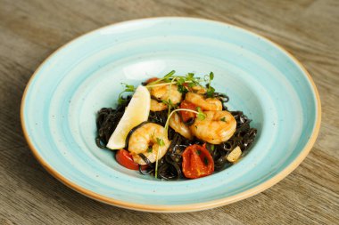 Karides, acı biber ve sarımsaklı siyah tagliatelle makarna.