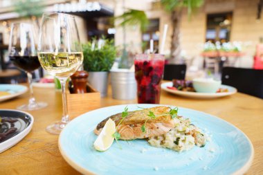 Açık bir masada pilavlı ve mantarlı ızgara somon balığı.