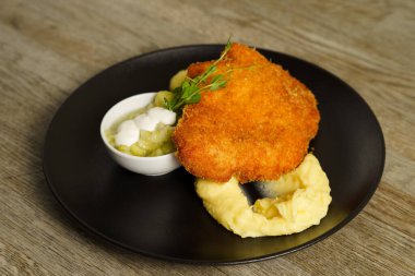 Şnitzel, kızarmış tavuk, salatalık salatası ve patates püresi.