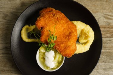 Şnitzel, kızarmış tavuk, salatalık salatası ve patates püresi.