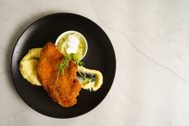 Şnitzel, kızarmış tavuk, salatalık salatası ve patates püresi.