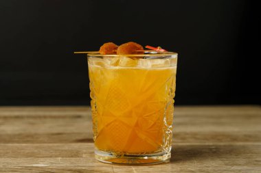 Ahşap masada kurutulmuş şeftali ve buzlu bir kokteyl.