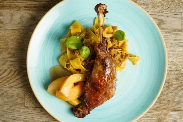Roasted goose leg with cabbage papardelle pasta and quince compote