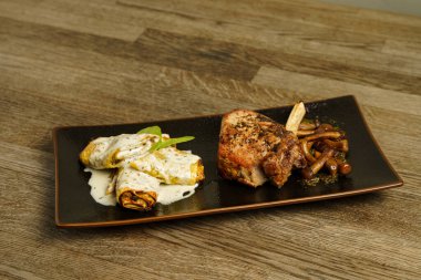 Mantarlı iğrenç pirzola ve ahşap masada küflü peynir soslu makarna.