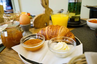 Ev yapımı reçelli kruvasan, krema ve taze portakal suyu.