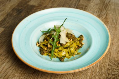 Pesto soslu makarna ve ince dilimler halinde peynir.