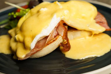Tahta bir masada jambonlu Benedict yumurtası.