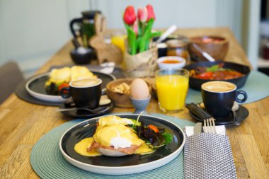 Kahvaltı masasında jambonlu Benedict yumurtası.