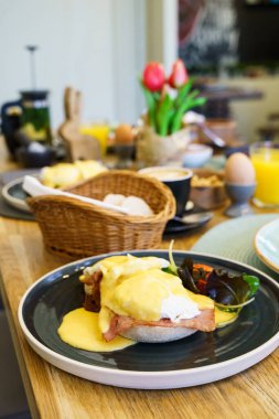 Tahta bir masada jambonlu Benedict yumurtası.