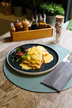 Tahta bir masada jambonlu Benedict yumurtası.