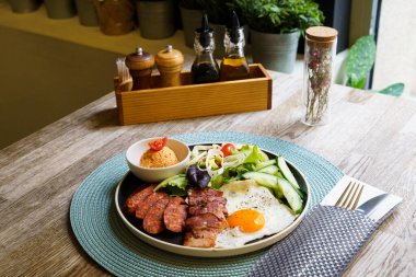 Pastırmalı kahvaltı, kızarmış yumurta, sosis ve salata.