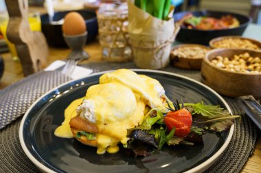 Tahta bir masada somonlu Benedict yumurtası.