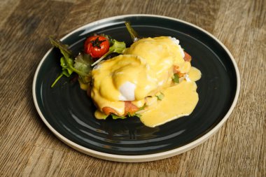 Tahta bir masada somonlu Benedict yumurtası.