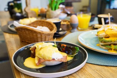 Tahta bir masada jambonlu Benedict yumurtası.