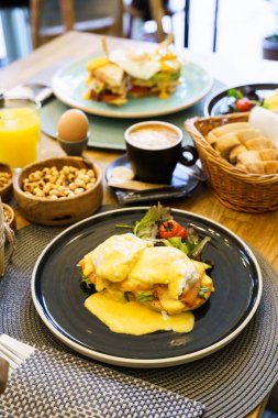 Tahta bir masada somonlu Benedict yumurtası.