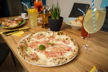 Restoranda peynirli ve jambonlu orijinal İtalyan pizzası.