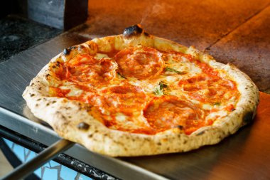 İtalyan pizza fırınından kızarmış pizza çıkarıyorum.