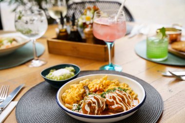 Şnitzel, makarna ve salata da dahil olmak üzere çeşitli gurme yemeklerden oluşan güzel bir açık hava yemek masası. Yanında da kokteyller ve şarap..