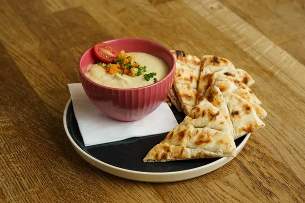 Kâsede taze humus ve Yunan pide ekmeği.