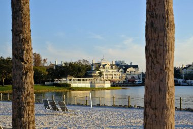 Arka planda binaların ve ön planda palmiye ağaçlarının yansımalarıyla güzel manzaralı bir sahil.