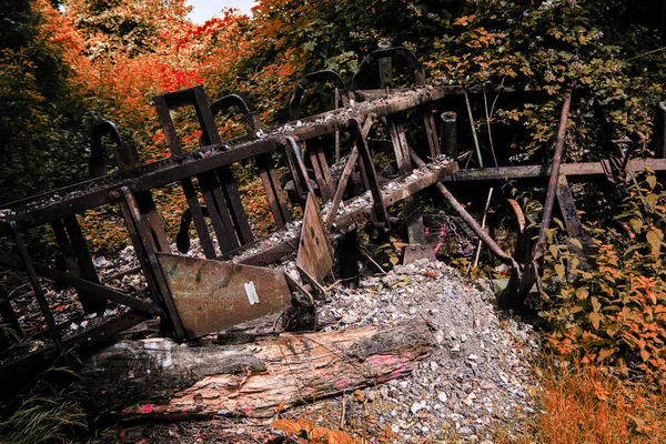 Old broken down tractor cultivator abandoned in the woods in autumn fall