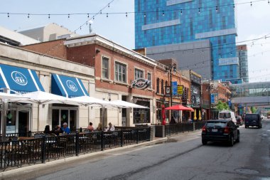 DETROIT, MICHIGAN, UNITED STATES - 22 Mayıs 2018: Detroit 'in Yunan Mahallesi' nde tarihi binalarda restoranlar ve arka planda bir gökdelen bulunan cadde.