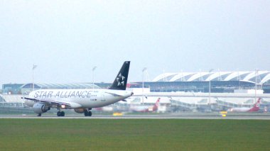 11 Ekim 2015 'te Münih Havalimanı' nda yakalanan bu fotoğraf, kalkış sırasında ön planda bir uçak olduğunu ve arka planda havaalanı kompleksinin açıkça görülebildiğini gösteriyor. Görüntü şu şekildedir: