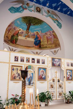 Küçük bir ortodoks kilisesinin içi bomboş. Simgeler, azizlerin olduğu duvar resimleri, yazı tipi ve sunak. Şifacı Aziz Panteleimon Kilisesi, Khmelnitsky, Ukrayna - 27 Kasım 2021 