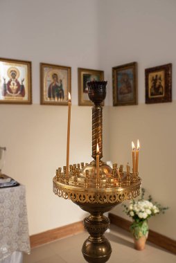 Altın bir şamdanda yanan mumlar tapınağın simgeleriyle dolu, parlak, kutsal bir iç mekanın arka planında. Şifacı Aziz Panteleimon Kilisesi, Khmelnitsky, Ukrayna - 27 Kasım 2021 