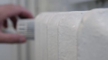 Man Check the Radiator Heat and Rotate the Thermostat Making Lower or Higher Temperature in the Room. Energy Economy Concept.