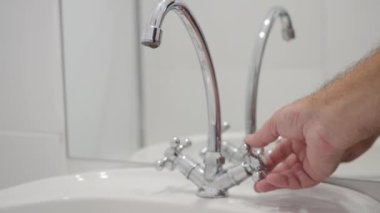 Shooting with a Person Who Opens a Water Tap in the Bathroom. Opening the Water from the Restroom Faucet. Wasting Water Concept.