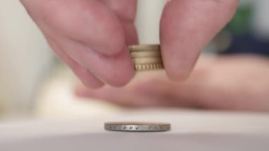 Man Putting Metallic Coins on Top of Each Other Making a Stock, Calculating Expenses and Trying to Make Economy. Financial Concept of Man Planning Savings and Expenses with Cash Money.