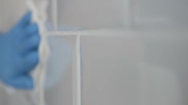 Man Wearing Gloves in Hands Cleans Bathroom Faience. Household Chores, Cleaning and Sanitizing the Faience in the Kitchen.