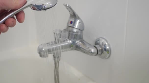 与使用浴室淋浴头的人进行模糊射击 男人用洗澡水准备洗澡水 — 图库视频影像