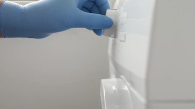A Hand Starting and Setting the Washing Machine from a Button. Housekeeper Sets the Laundry Machine Function from Setting Panel.