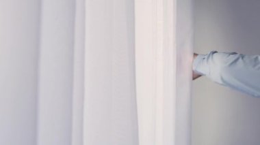 One Person Opening a White Curtain on the Window. Man Moving the Drapes on the Window in a Room.