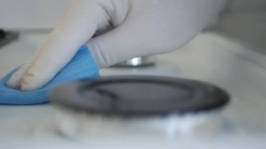 Man Cleaning the Gas Cooker with a Clean Wipe and Cleaning Solution. Daily Household Chores in the Kitchen.