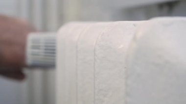 Man Check the Radiator Heat and Rotate the Thermostat Making Lower or Higher Temperature in the Room. Energy Economy Concept.
