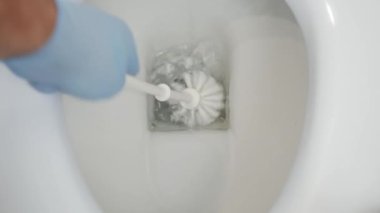 Man Cleaning Toilet Bowl with a Brush and Clean Water. Household Chores, Cleaning the Toilet Bowl at Home.