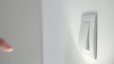 Shooting with a Hand Pushing the Switch and Shutting Down the Light in a Room. Businessman Turning Off the Light in the Office.