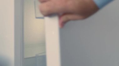 Man Hand Opens an Empty Fridge Door Looking Inside for Fresh Food and Drink. Empty Fridge, Food Crisis Concept.