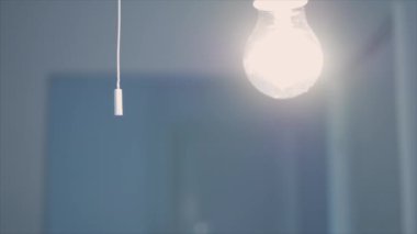 One Person Pulls the Switch Cord and Turns Off the Light in a Room. Saving Electricity and Making Economy Concept.