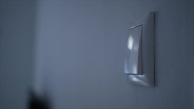 Opening the Light from the Switch in the Office. One Person Turning on the Light in a Room. Saving Electricity, Economy Concept.